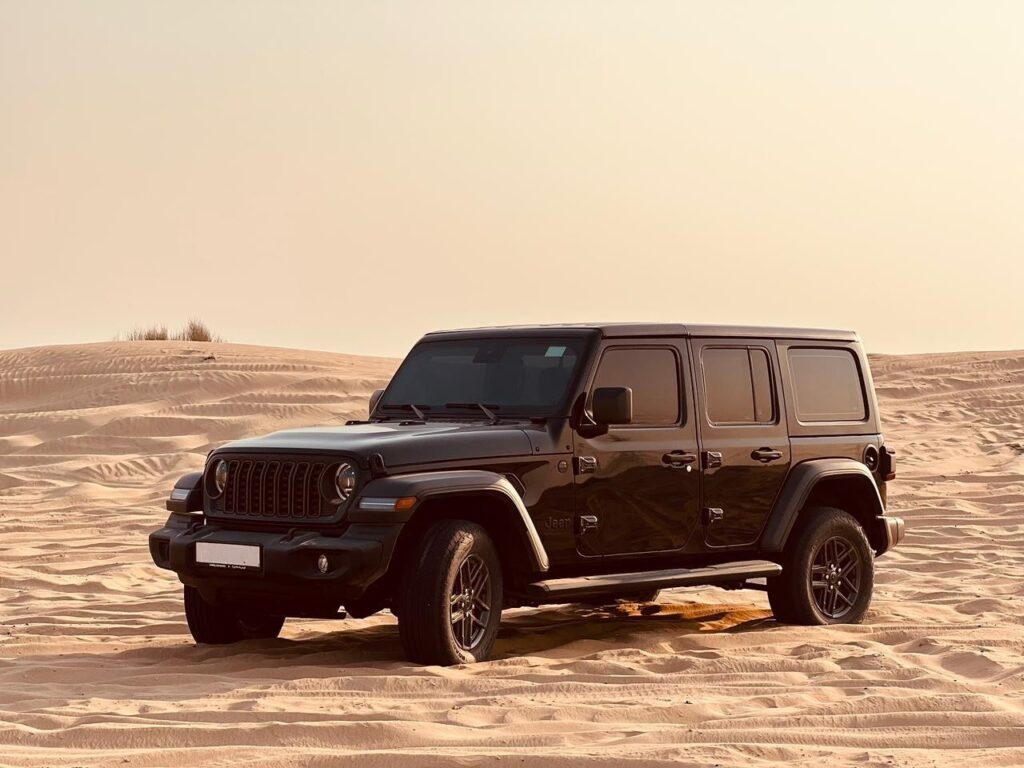 Customer driving Jeep Wrangler rental Dubai desert adventure