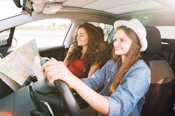 cheerful-woman-driving-car_23-2147932101